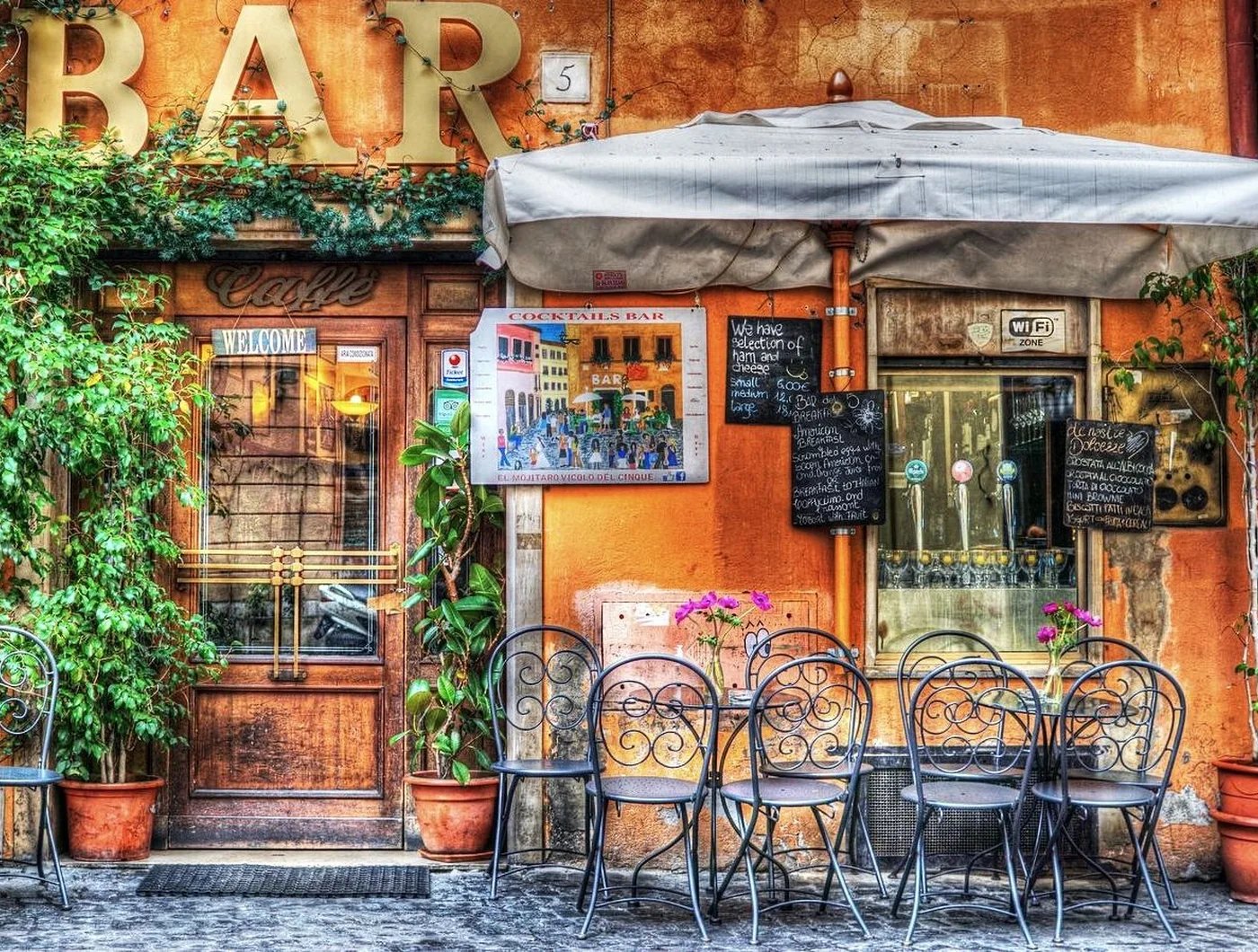 A bar terrace under an awning on a warm evening